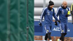 Javier Mascherano (kanan) dan Lionel Messi memasuki lapangan saat sesi latihan di City Football Academy, Manchester, (20/3/2018). Argentina akan melawan Italia pada laga persahabatan di Etihad Stadiu. (AFP/Anthony Devlin)