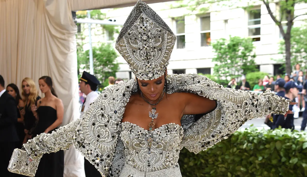 Penyanyi Rihanna menghadiri pagelaran Met Gala 2018 di Museum Seni Metropolitan New York, Senin (7/5). Kali ini Rihanna mengenakan busana layaknya Paus di Katedral rancangan John Galliano dari Maison Margiela Artisanal. (Evan Agostini/Invision/AP)