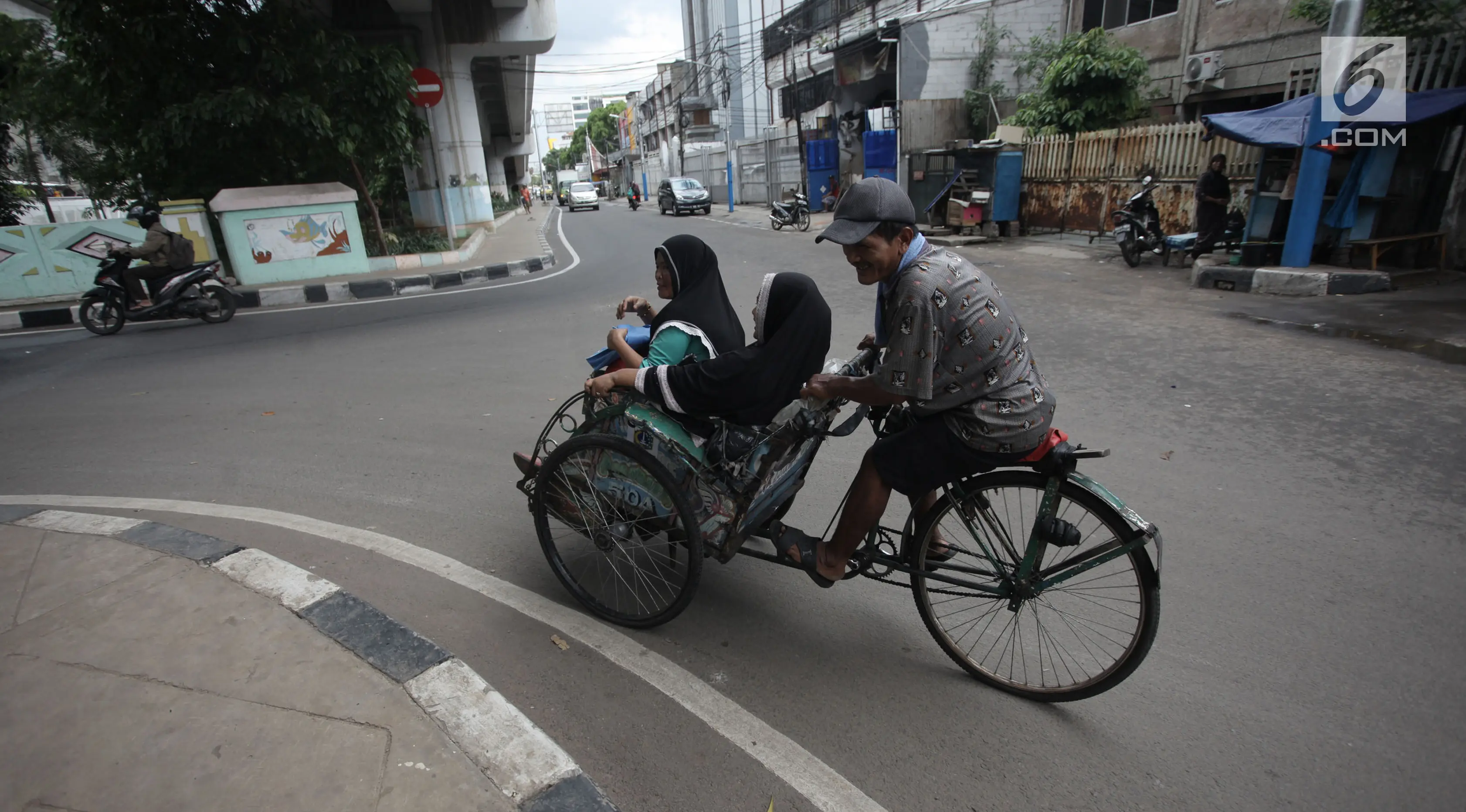 Tukang becak mengangkut penumpang saat melintas di Kolong Flyover Bandengan Utara, Jakarta, Kamis (25/1). Petugas melakukan pendataan becak diperuntukkan bagi becak-becak yang sudah lama beroperasi di Jakarta. (Liputan6.com/Arya Manggala)