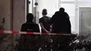 Polisi mengamankan seorang pria di dekat lokasi penembakan di Hanau, Jerman, Kamis (20/2/2020). Penembakan pertama terjadi sebuah bar shisha bernama Midnight di pusat kota. Lalu penembakan kedua terjadi di bar Arena Bar & Cafe di area Kesselstadt. (Boris Roessler/dpa via AP)