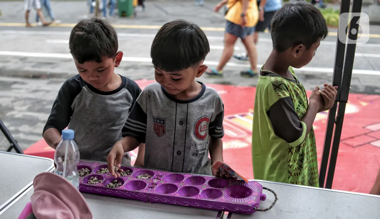 Anak-anak bermain permainan tradisional di kawasan Kota Tua, Jakarta Barat, Minggu (13/11/2022). Festival ini digelar untuk memperkenalkan permainan tradisional kepada anak sekaligus menguji ketangkasan di tengah gempuran gawai teknologi. (merdeka.com/Iqbal S. Nugroho)