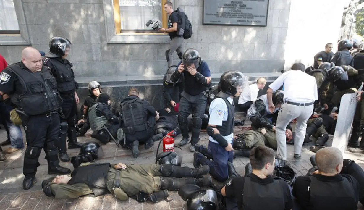 Sejumlah polisi terluka akibat ledakan di depan gedung Parlemen Ukraina di Kiev, Senin (31/8). Seorang petugas tewas dan 90 orang lainnya terluka dalam aksi yang menentang perubahan UU dasar mengenai desentralisasi. (AFP PHOTO/Yuriy KIRNICHNY)
