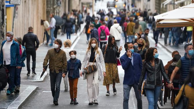 Orang-orang memakai masker untuk mencegah penyebaran COVID-19 saat mereka berjalan di pusat kota Roma pada Sabtu (3/10/2020). Masker wajah harus dipakai setiap saat di luar rumah di ibu kota Italia, Roma dan wilayah sekitar Lazio mulai Sabtu, 3 Oktober. (AP Photo/Andrew Medichini)