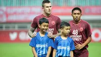Aaron Evans dan Player Escort Kids Allianz pada lanjutan penyisihan Grup H Piala AFC 2019 antara PSM Makassar Vs Home United, Selasa (30/4/2019) di Stadion Pakansari, Kab. Bogor. (Bola.com/Vitalis Yogi Trisna)