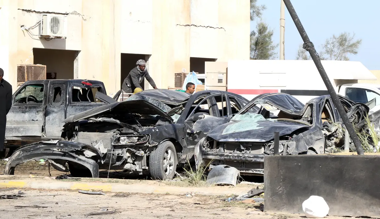 Sejumlah mobil rusak akibat bom truk yang meledak di sekolah polisi di kota Zliten, wilayah barat Libya, Kamis (7/1). Belum ada yang mengaku bertanggung jawab terkait serangan bom yang menewaskan sedikitnya 50 orang tersebut. (AFP PHOTO/MAHMUD Turkia)