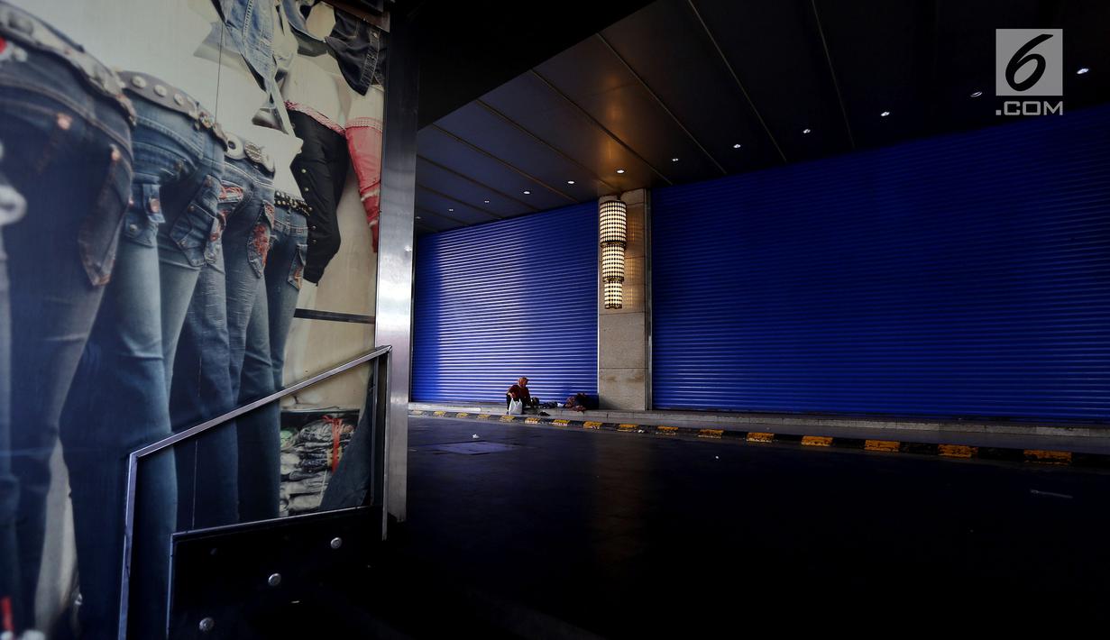 Seorang warga duduk di emperan toko yang tutup di Blok B Pasar Tanah Abang, Jakarta, Selasa (27/6). Dalam rangka libur lebaran, Pasar Tanah Abang tutup mulai Minggu (25/7) hingga buka kembali pada tanggal 3 Juli 2017. (Liputan6.com/Johan Tallo)