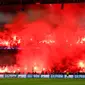 Pendukung Paris Saint-Germain menyalakan suar saat PSG melawan Real Madrid di pertandingan Liga Champions leg kedua di stadion Parc des Princes di Paris (6/3). Mereka juga menyanyikan lagu bernada cemoohan kepada Real Madrid. (AP Photo / Francois Mori)