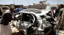 Warga memeriksa sebuah mobil yang hancur akibat serangan udara yang dipimpin koalisi militer Saudi di Kota Sanaa, Yaman, (4/9). Serangan udara Saudi tersebut banyak  menewaskan warga sipil yang tak berdosa. (REUTERS/Mohamed al-Sayaghi)
