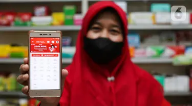 Pemilik toko kelontong menunjukkan aplikasi Pojok Bayar di layar hand phone, di Jakarta, Selasa (25/06/2021). Inovasi Pojok Bayar yang disediakan SRC Indonesia memberikan kemudahan dan kenyamanan membeli pulsa, tiket pesawat dan kereta api hingga voucher game. (Liputan6.com/HO/SRC)