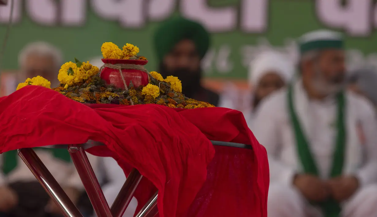 Abu petani yang terbunuh selama protes terhadap undang-undang pertanian disimpan di atas meja selama protes solidaritas dengan petani, di Mumbai, India, Minggu (28/11/2021). Kelompok tani menunggu undang-undang pertanian yang kontroversial untuk secara resmi ditarik. (AP Photo/Rafiq Maqbool)