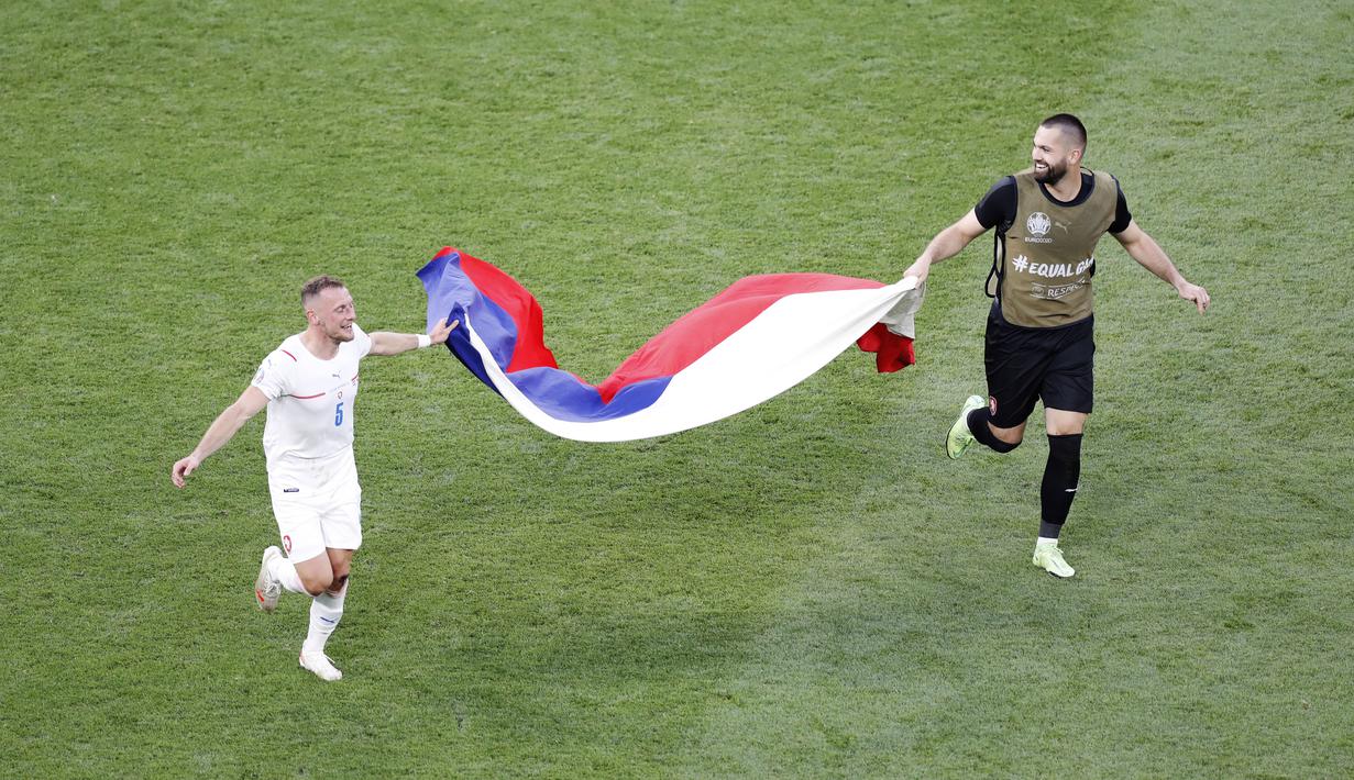 Pemain Republik Ceska, Vladimir Coufal, bersama rekannya membawa bendera negaranya saat merayakan kemenangan atas Belanda pada babak 16 besar Euro 2020 di Puskas Arena, Minggu (27/7/2021). (AP Photo/Laszlo Balogh, Pool)