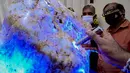 Orang-orang mengamati permata yang diklaim sebagai safir biru korundum alami terbesar di dunia di Horana, sekitar 45 km dari Kolombo, 12 Desember 2021. Ahli permata Sri Lanka mengatakan itu adalah salah satu permata paling langka di dunia karena beratnya lebih dari 300 kg. (Ishara S. KODIKARA/AFP)