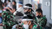 Prajurit TNI menggunakan pelindung wajah berjaga di Stasiun Pasar Senen, Jakarta, Jumat (10/7/2020). PT. KAI membagikan face shield kepada penumpang bertujuan memudahkan masyarakat tetap dapat menjaga physical distancing di tengah pandemi COVID-19. (Liputan6.com/Faizal Fanani)