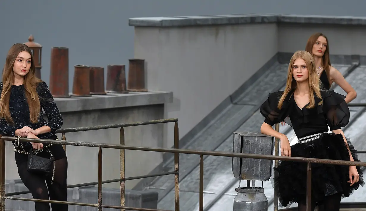 Gigi Hadid berpose bersama para model saat mengenakan busana koleksi desainer Virginie Viard dalam Paris Fashion Week, di Prancis (1/10/2019). Gigi Hadid membawakan koleksi women's ready-to-wear 2020 dari rumah mode Chanel. (AFP Photo/Christophe Archambault)