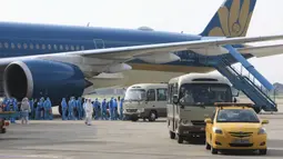 Pasien COVID-19 asal Vietnam mengenakan alat pelindung diri saat tiba di Bandara Noi Bai, Hanoi, Vietnam, Rabu (29/7/2020). Sebanyak 129 pekerja asal Vietnam dipulangkan dari Equatorial Guinea untuk mendapat perawatan COVID-19. (Tran Huy Hung/VNA via AP)