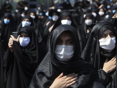 Umat Syiah mengenakan masker saat memperingati Hari Asyura di Teheran, Iran, Minggu (30/8/2020). Ritual untuk memperingati wafatnya Imam Hussein tersebut digelar dengan menerapkan jarak sosial dan mewajibkan penggunaan masker. (AP Photo/Ebrahim Noroozi)