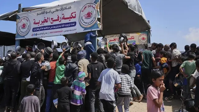 Warga Palestina berjuang mendapatkan sumbangan makanan di dapur umum di Khan Younis, Jalur Gaza, Senin (5/5/2025).
