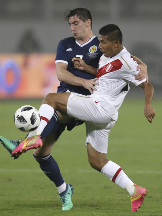 Aksi pemain Peru, Edison Flores (kanan) melepaskan tembakan saat diadang pmeian Skotlandia, Kenny McLean pada laga uji coba di Lima, Peru, (29/5/2018). Peru menang 2-0. (AP/Martin Mejia)
