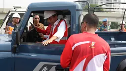 Presiden Joko Widodo (Jokowi) menaiki mobil jip seusai meresmikan jalan Tol Bekasi-Cawang-Kampung Melayu (Becakayu), Jumat (3/11). Bersama rombongan, Jokowi konvoi menjajal ruas tol sepanjang 8,26 km itu. (Liputan6.com/Angga Yuniar)