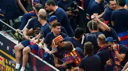 Lionel Messi (tengah) dan sejumlah punggawa Barcelona lainnya berpesta juara bus terbuka di sepanjang jalan Barcelona , Spanyol , 15 Mei 2016. Barcelona sukse merengkuh juara Liga Spanyol yang ke-24. (REUTERS / Albert Gea)