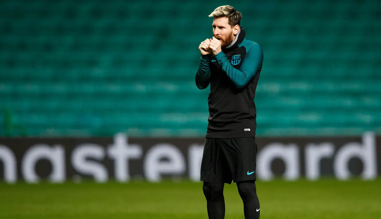 Penyerang Barcelona, Lionel Messi, tampak kedinginan saat berlatih jelang laga Liga Champions melawan Celtic. Laga Barca melawan Celtic akan berlangsung di Celtic Park pada Rabu (23/11/2016) dini hari WIB. (EPA/Robert Perry)