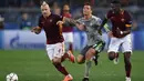 Pergerakan dari bintang Real Madrid, Cristiano Ronaldo, ditahan dua pemain Roma. Gol ke gawang Roma itu kian mengokohkan dirinya sebagai pencetak gol terbanyak Liga Champions sepanjang masa dengan torehan 89 gol. (AFP/Alberto Pizzoli)