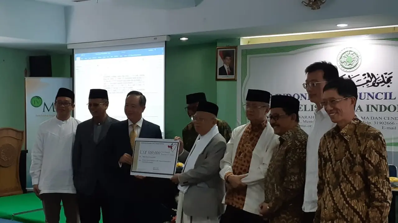 (Memegang plakat) Kepala TETO John Chen dan Ketua MUI KH Ma'ruf Amin, dalam penyerahan simbolis bantuan kemanusiaan dari Taiwan untuk korban gempa-tsunami di Sulawesi Tengah (9/10). MUI bertindak sebagai penyalur bantuan. (Rizki Akbar Hasan/Liputan6.com)
