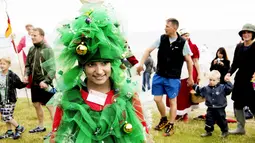 Kostum unik salah satu peserta Kongres Santa Claus Dunia 2015 saat bersiap berenang di pantai Bellevue di Copenhagen, Denmark, Minggu (21/7/2015). (REUTERS/Scanpix Denmark/Erik Refner)