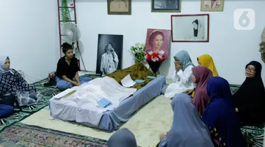 Sejumlah kerabat dan anggota keluarga berdoa di dekat jenazah artis senior Ade Irawan di rumah duka kawasan Lebak Buluk, Jakarta Selatan, Jumat (17/1/2020). Ibunda Ria Irawan tersebut meninggal dunia di Rumah Sakit Fatmawati pada Jumat (17/1/2020) pada usia 82 tahun. (Liputan6.com/Johan Tallo)