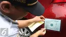 Petugas memasang kir mobil peserta saat tes uji SIM dan kir transportasi online di Jakarta, (15/8). Kegiatan diadakan menyambut HUT Kemerdekaan RI ke-71 serta menciptakan layanan angkutan umum yang prima dan accountable. (Liputan6.com/Immanuel Antonius)