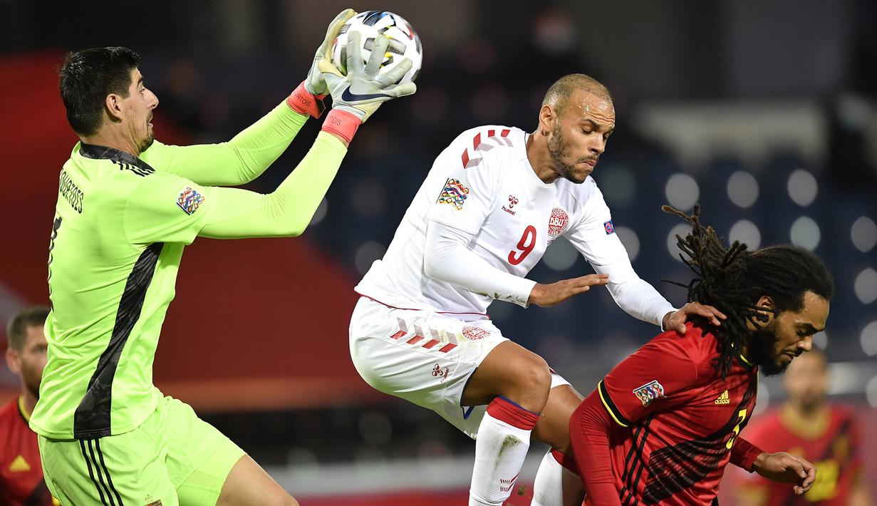Kiper Belgia, Thibaut Courtois, berusaha menangkap bola saat menghadapi Denmark pada laga lanjutan UEFA Nations League di Stadion Den Dreef, Kamis (19/11/2020) dini hari WIB. Belgia menang 4-2 atas Denmark. (AFP/John Thys)
