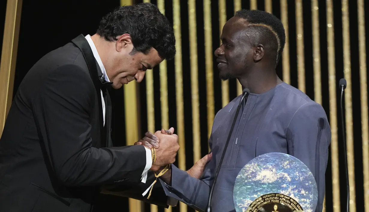 Penghargaan tersebut diserahkan langsung oleh Rai (kiri), mantan pemain timnas Brasil dan Paris Saint-Germain. Rai juga merupakan adik laki-laki Socrates, pesepakbola yang juga terlibat dalam aksi sosial di Brasil. (AP/Francois Mori)