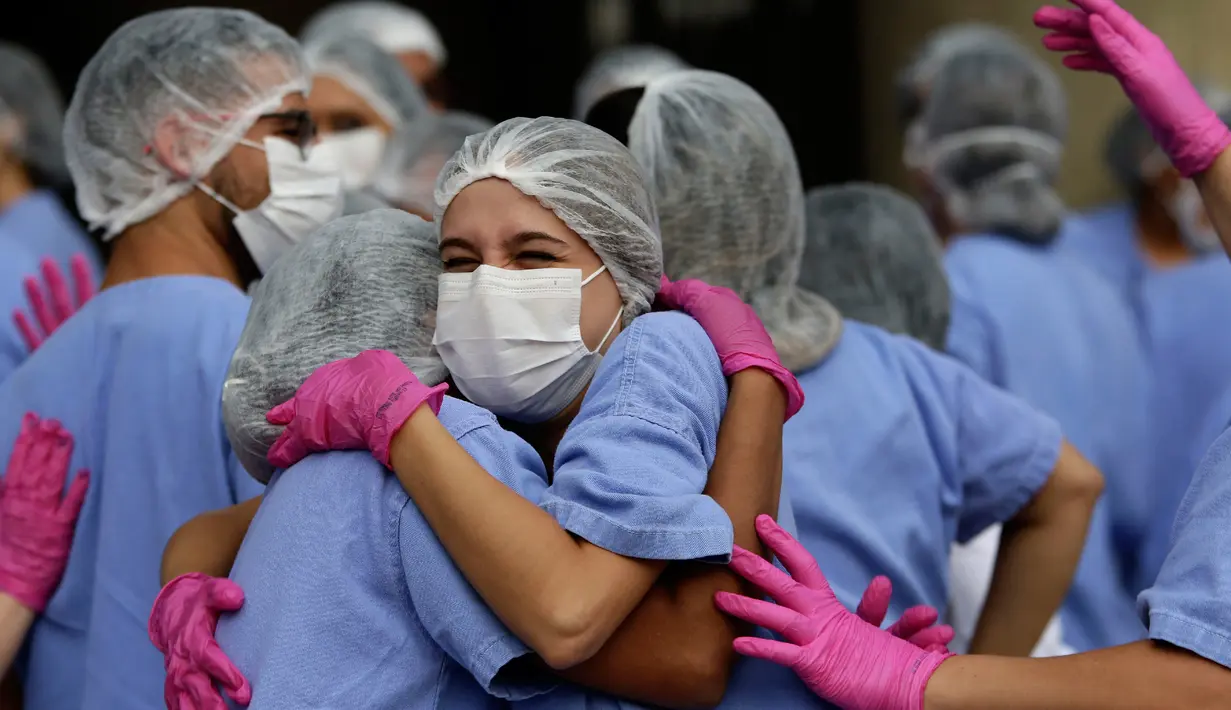 Petugas medis merayakan ketika tiga pasien terakhir meninggalkan rumah sakit lapangan di Stadion Nasional Mane Garrincha di Brasilia, Brasil, Kamis (15/10/2020). Para tenaga kesehatan berkumpul saat pasien COVID-19 terakhir pulang setelah dinyatakan sembuh. (AP Photo/Eraldo Peres)