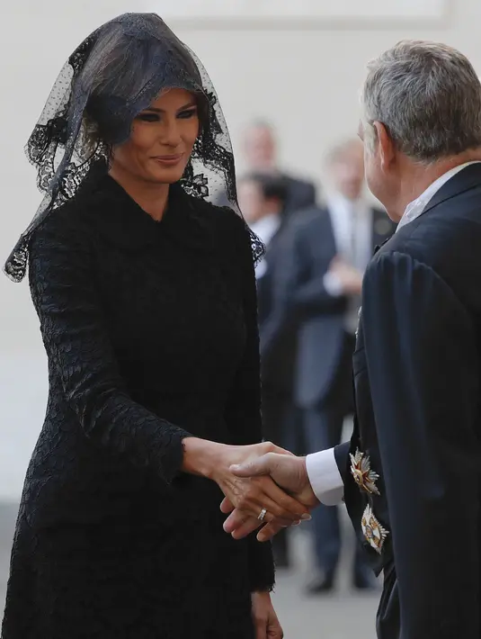 Ibu Negara AS, Melania Trump setibanya di halaman San Damaso, Vatikan untuk melakukan pertemuan dengan Paus Fransiskus, Rabu (24/5). Dalam pertemuan itu, Melania terlihat cantik dengan gaun hitam dan kerudung renda di kepalanya. (AP Photo/Gregorio Borgia)