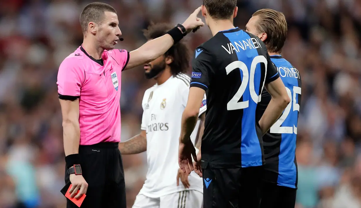 Pemain Club Brugge Ruud Vormer (kanan) mendapat kartu merah dari wasit Georgi Kabakov pada laga Liga Champions di Stadion Santiago Bernabeu, Madrid, Spanyol, Selasa (1/10/2019). Pertandingan berakhir 2-2. (AP Photo/Manu Fernandez)