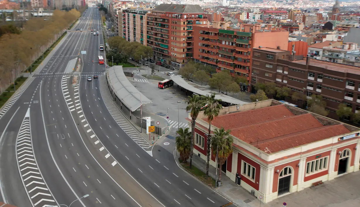 Sebuah jalan terlihat kosong di Barcelona, Spanyol, Minggu (15/3/2020). Pemerintah Spanyol memberlakukan lockdown selama 15 hari ke depan untuk menghambat penyebaran virus corona COVID-19. (AP Photo/Joan Mateu)
