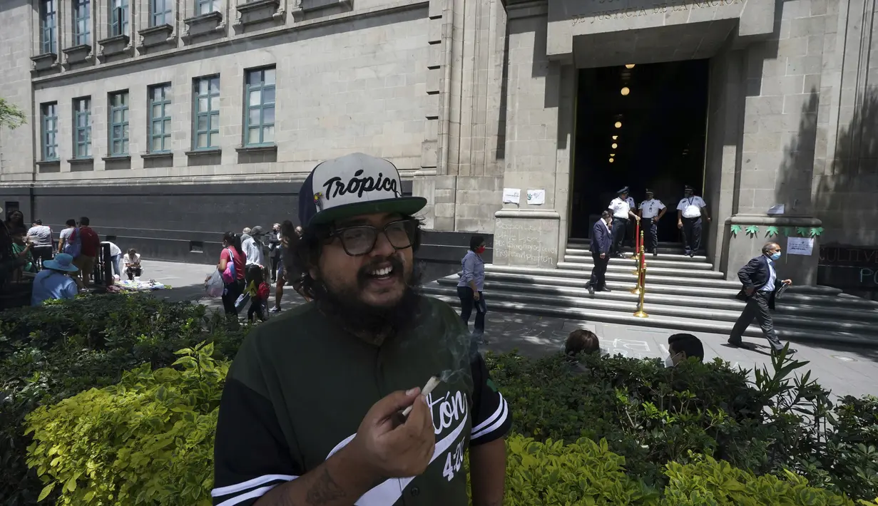 Seorang aktivis pro-ganja merokok ganja di luar Mahkamah Agung Meksiko di Mexico City, Rabu (11/5/2022). Mahkamah Agung diperkirakan akan segera memutuskan undang-undang yang akan mengubah batas berapa banyak ganja yang dapat dibawa secara legal oleh seseorang. (AP Photo/Fernando Llano)
