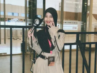 Melihat unggahan Adiba Khanza, banyak netizen yang baru mengetahui jika Adiba adalah seorang Kpopers. Adiba tampil dengan dress warna krem dipadukan dengan outer warna senada. Kakak Abidzar ini mengenakan jilbab warna hitam yang selaras dengan aksen garis pada outernya dan sepatu boots yang dikenakannya. Tak lupa Adiba membawa lightstick agar konser makin seru. (Liputan6.com/IG/@adiba.knza)