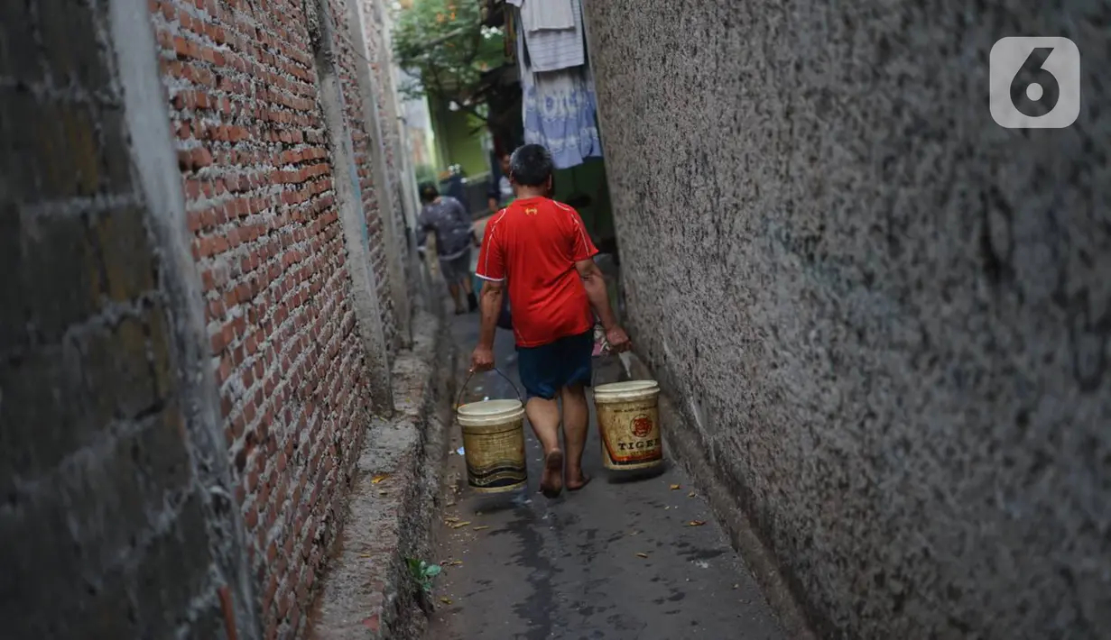 Warga membawa ember berisi air bersih di kawasan Cipayung, Jakarta Timur, Rabu (20/11/2019). Warga memanfaatkan bantuan air bersih dari Pemprov DKI Jakarta untuk memenuhi kebutuhan sehari-hari. (Liputan6.com/Immanuel Antonius)