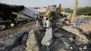 Orang-orang berdiri di lokasi kebakaran di sebuah pabrik di kawasan industri di pinggiran Ahmedabad, India (4/11/2020). Menurut pejabat setempat, puluhan orang tewas ketika sebagian gudang bahan kimia runtuh setelah terjadi ledakan dahsyat. (AP Photo/Ajit Solanki)
