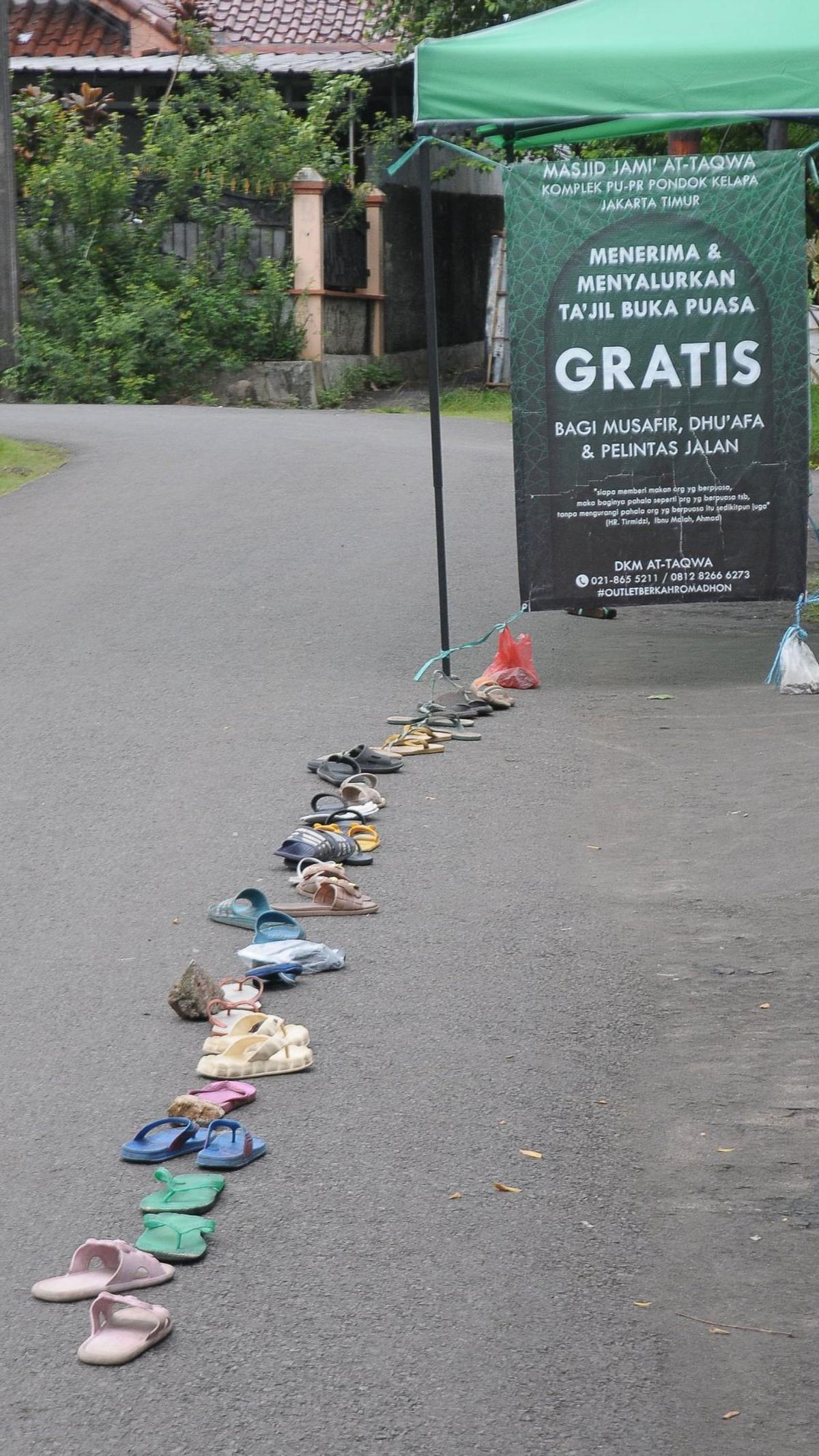 Kegiatan bagi-bagi takjil ini mendapatkan sambutan antusias. Bahkan, warga sudah menempatkan sandal di garis antrean agar mendapatkan takjil dari Masjid At-Taqwa tersebut.&nbsp;Merdeka.com/Imam Buhori
