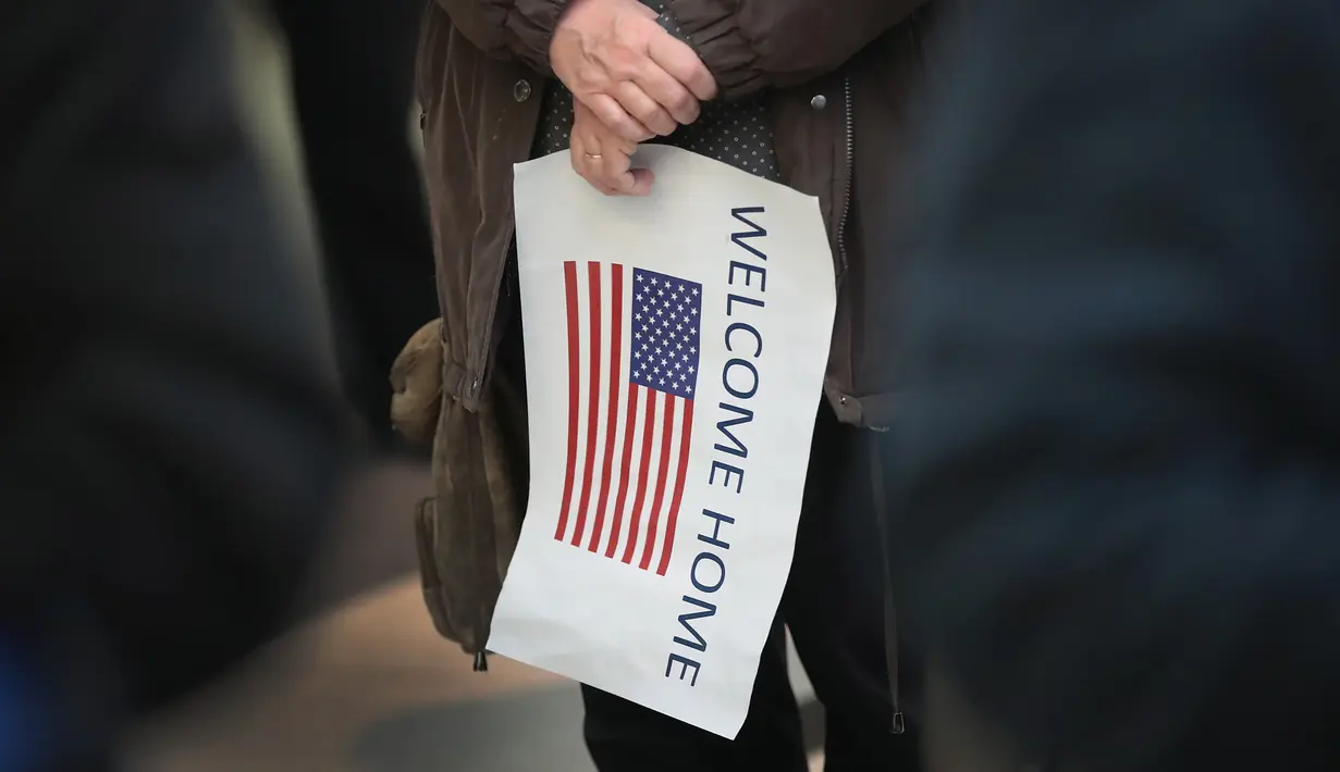 Sebuah poster menyambut kedatangan Baraa Haj Khalaf di bandara Internasional O'Hare, AS, Rabu (7/2). Baraa dan keluarganya nyaris tidak bisa ke AS bila kebijakan Presiden Trump tidak dicabut. (AFP Photo/ Scott Olson)