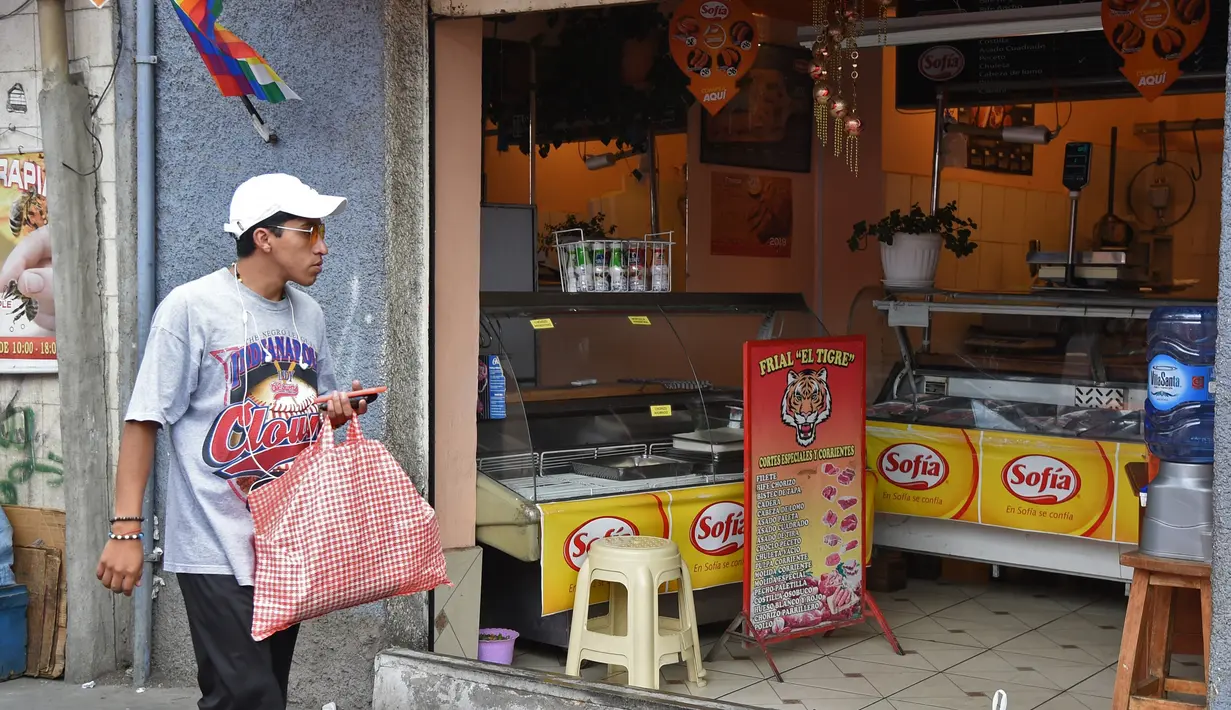 Seorang pria berbelanja bahan makanan di Pasar Rodriguez, La Paz, pada 16 November 2019. Pemblokiran jalan yang dilakukan pendukung mantan Presiden Bolivia Evo Morales membuat kelangkaan bahan makanan, terutama daging dan telur, mulai sulit ditemukan di pasar. (AIZAR RALDES/AFP)