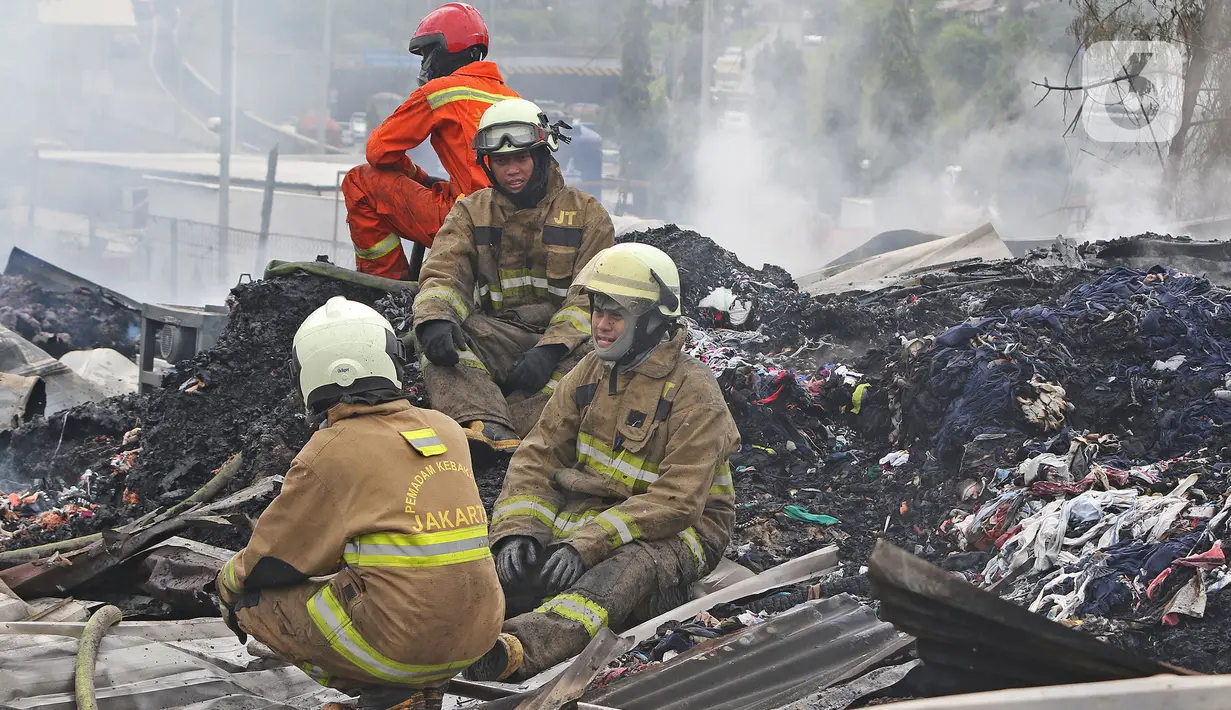 Petugas pemadam kebakaran beristirahat di Pabrik penggilingan kapas yang terbakar di  Pasar Rebo, Jakarta Timur, Selasa (16/11/2021). Sudin Penanggulangan Kebakaran dan Penyelamatan (Gulkarmat) Jakarta Timur menurunkan 13  mobil pemadam kebakaran  untuk memadamkan api. (Liputan6.com/Herman Zakharia)