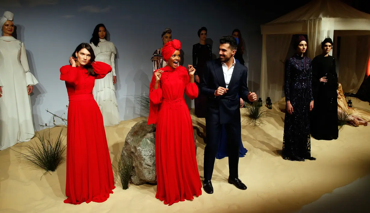 Desainer Turki Rasit Bagzibagli (tengah) berinteraksi dengan model Alima Aden saat peragaan busana di Istanbul, Turki (26/3). Meski berhijab, Halima Aden tidak merasa berbeda dari model lainnya di Amerika. (AP Photo / Lefteris Pitarakis)