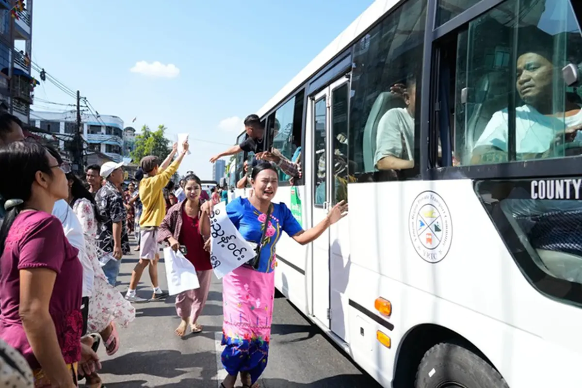 Para tahanan yang dibebaskan, berada di dalam bus, disambut oleh anggota keluarga dan rekan-rekan mereka setelah meninggalkan Penjara Insein pada Minggu (4/1/2026), di Yangon, Myanmar.