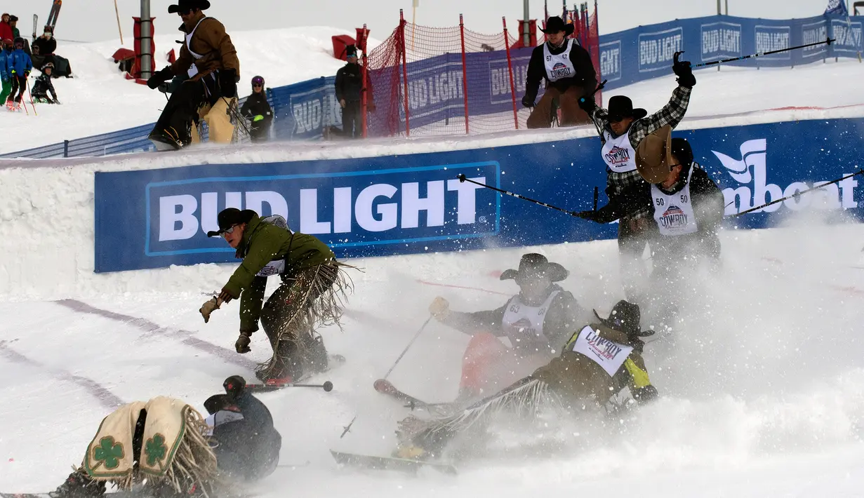 Para koboi rodeo saling bertabrakan saat melompat di atas papan luncur pada turnamen Cowboy Downhill ke-46 di Steamboat Springs, Colorado, 20 Januari 2020. Para koboi yang biasa menunggangi kuda atau banteng ini ditantang untuk meluncur menggunakan papan ski dan snowboard. (Jason Connolly/AFP)