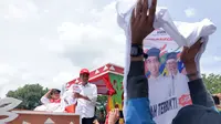 Capres nomor urut 1 Jokowi saat membagikan baju putih di Palembang (Liputan6.com / Nefri Inge)