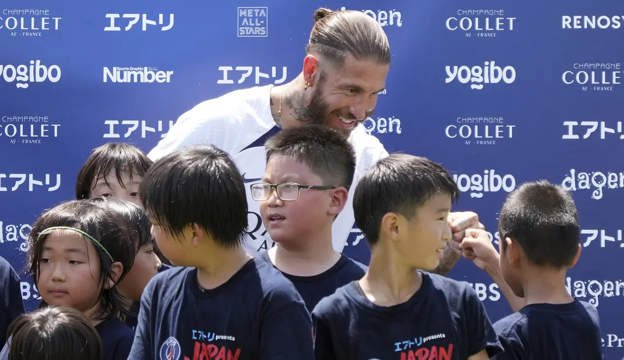 Pemain Paris Saint-Germain (PSG), Sergio Ramos menyapa pesepak bola cilik saat memberikan pelatihan di Jepang. (AP/Eugene Hoshiko)
