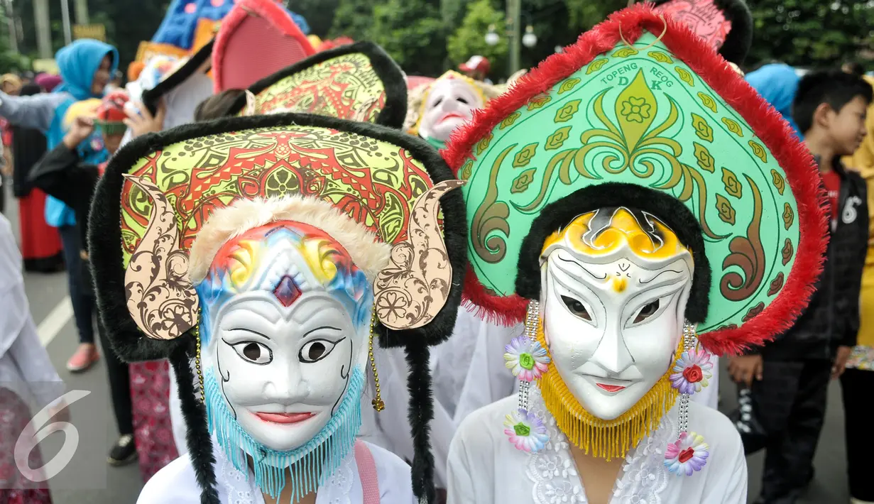 Peserta Kirab Budaya Merah Putih mengenakan topeng saat pawai, Bogor, Jawa Barat, Minggu (13/11). Acara ini bertujuan untuk memperkenalkan budaya bangsa kepada anak-anak muda dan sekaligus mempromosikan wisata Bogor. (Liputan6.com/Yoppy Renato)